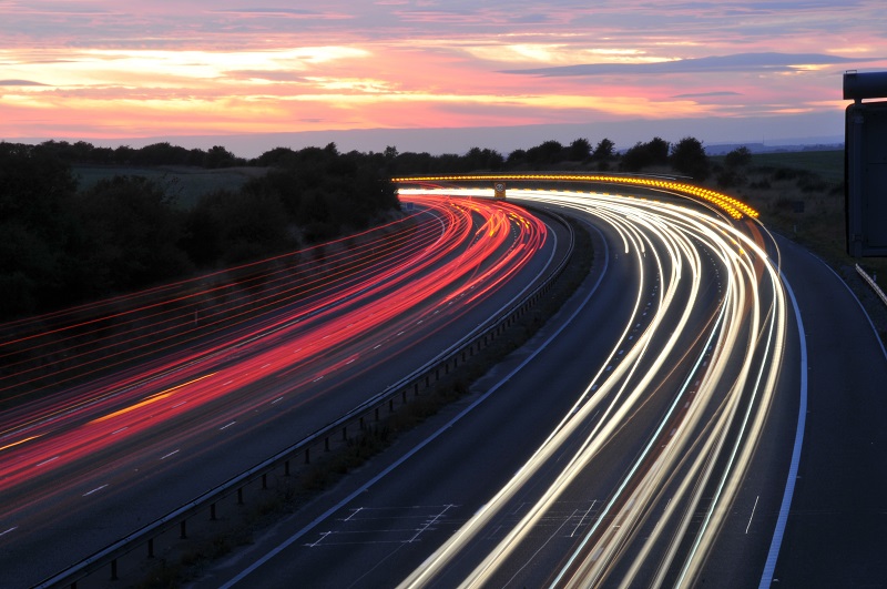 Light trails in road at sunset